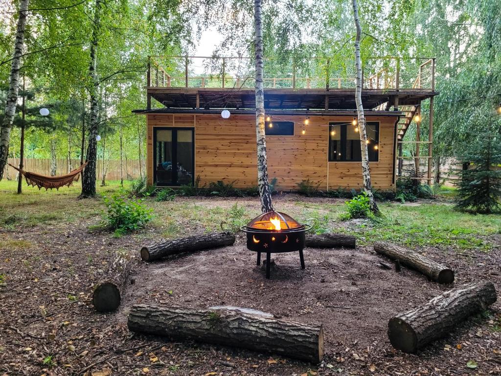 Cabaña de madera en el bosque con barbacoa y columpio en Domek nad Zegrzem, en Arciechow