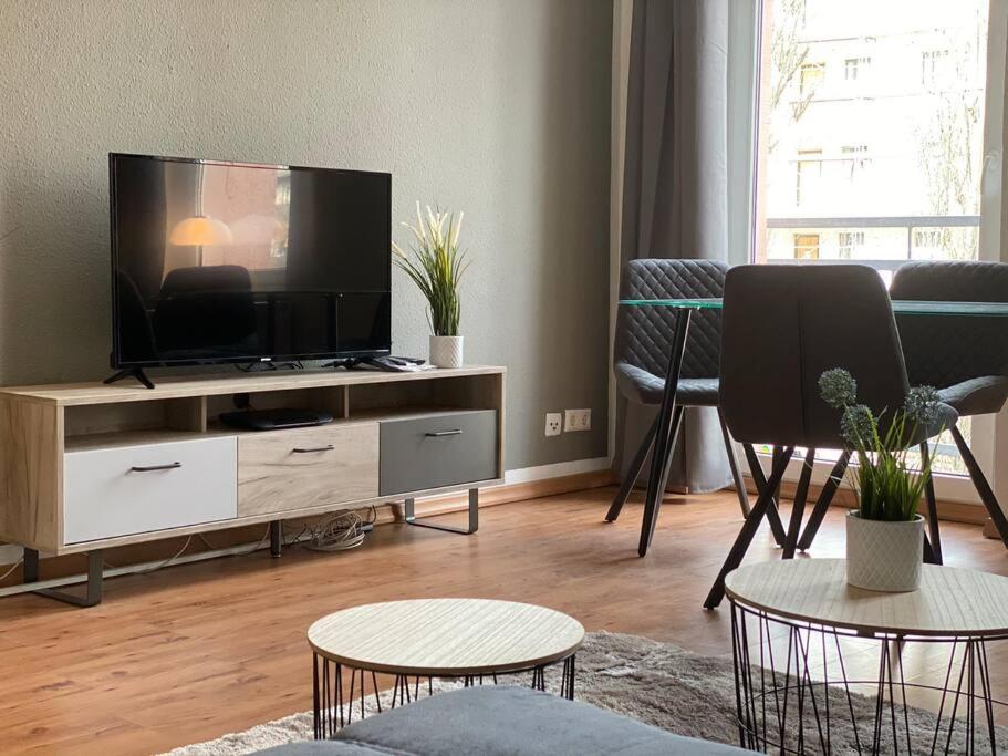 a living room with a flat screen tv on a entertainment center at AKK4 - Apartment MD Zentrum nähe Uni und Hbf in Magdeburg