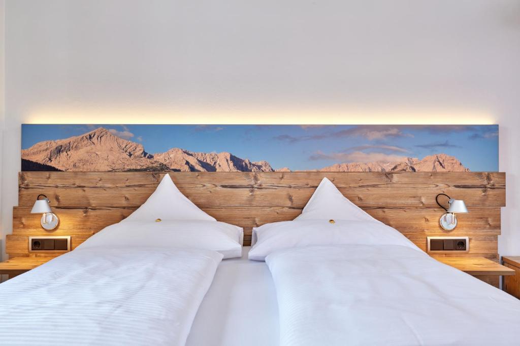a bedroom with two beds with mountains in the background at Gästehaus Angela in Garmisch-Partenkirchen