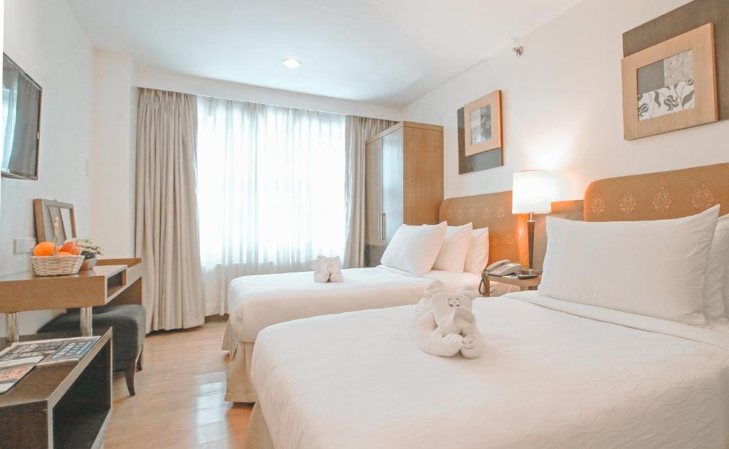Postel nebo postele na pokoji v ubytování One Tagaytay Place Hotel Suites OFFICIAL ACCOUNT
