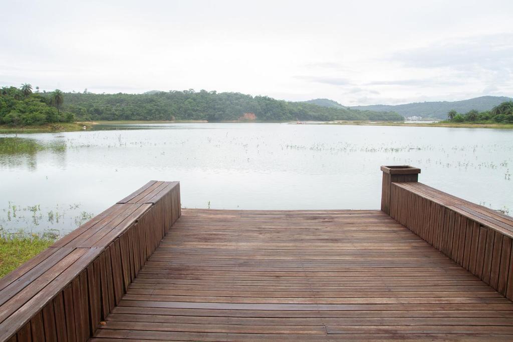 un molo in legno sopra un lago con vista di Chacara com WiFi de frente a lagoa em Betim MG a Betim