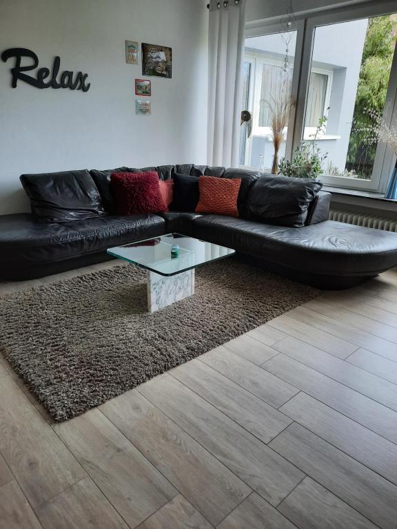a black leather couch with a coffee table in a living room at Ferienwohnung Heiming in Saarburg
