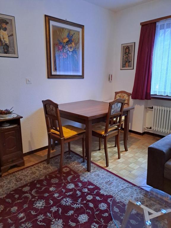 Casa Di Vacanza Cevio في Cevio: غرفة معيشة مع طاولة وكراسي خشبية