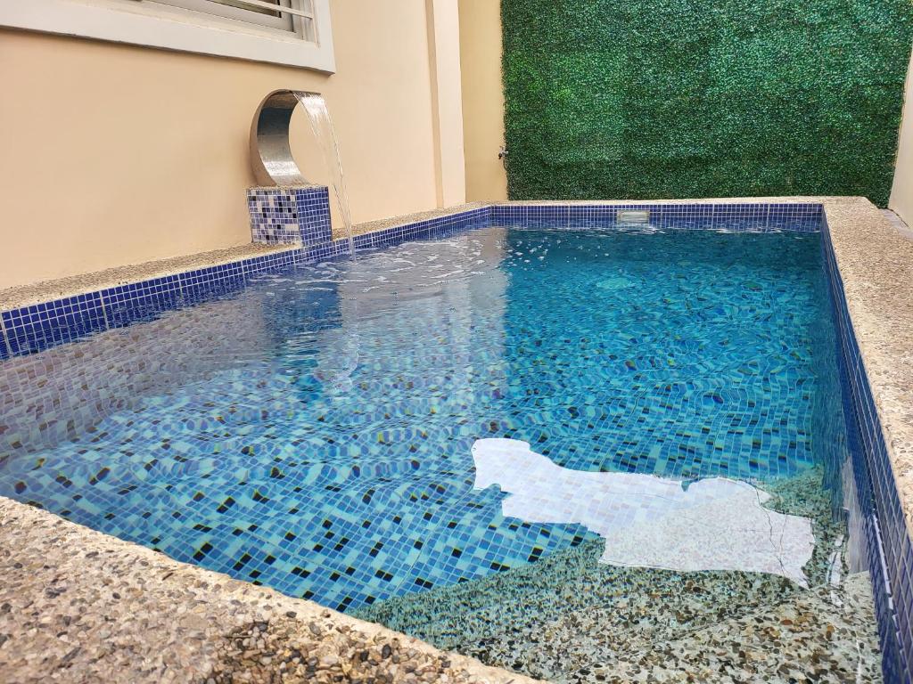 una piscina con suelo de baldosa azul y azulejos azules en Luxury 3BR Villa w Plunge Pool near SM Batangas City- Instagram-Worthy!, en Batangas