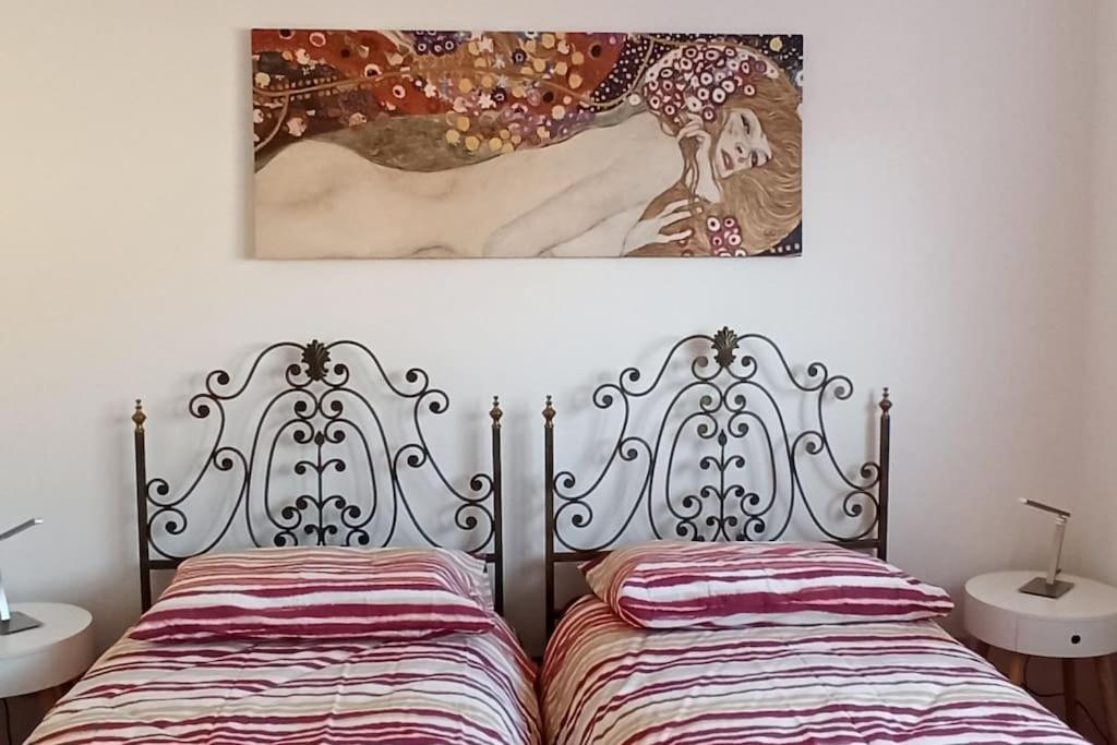 1 dormitorio con 1 cama y una pintura en la pared en Casa vacanze Donna Michela, en Ponzano Veneto