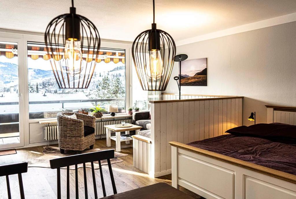 a bedroom with two chandeliers and a living room at Imbergblick in Oberstaufen