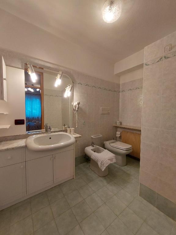 W łazience znajduje się umywalka, toaleta, wanna i umywalka. w obiekcie Agritur Widmann w mieście Coredo