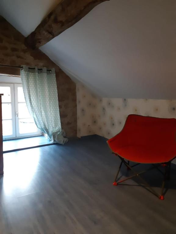 a red chair in a room with a window at CHEZ ROSALIE 