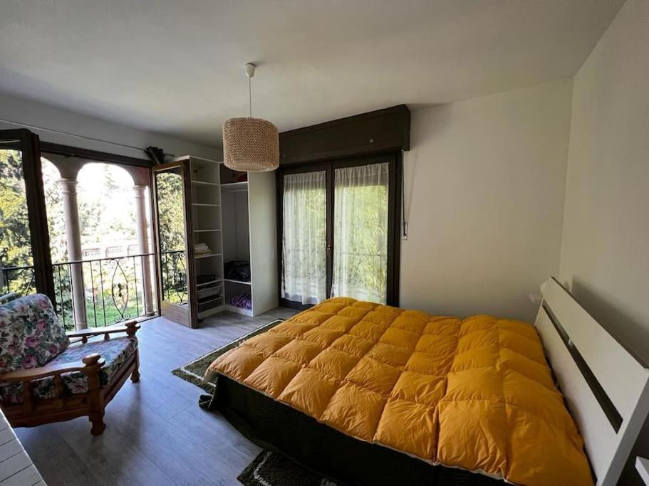 a bedroom with a large yellow bed and a chair at Appartamento in Villa Storica in Oleggio Castello