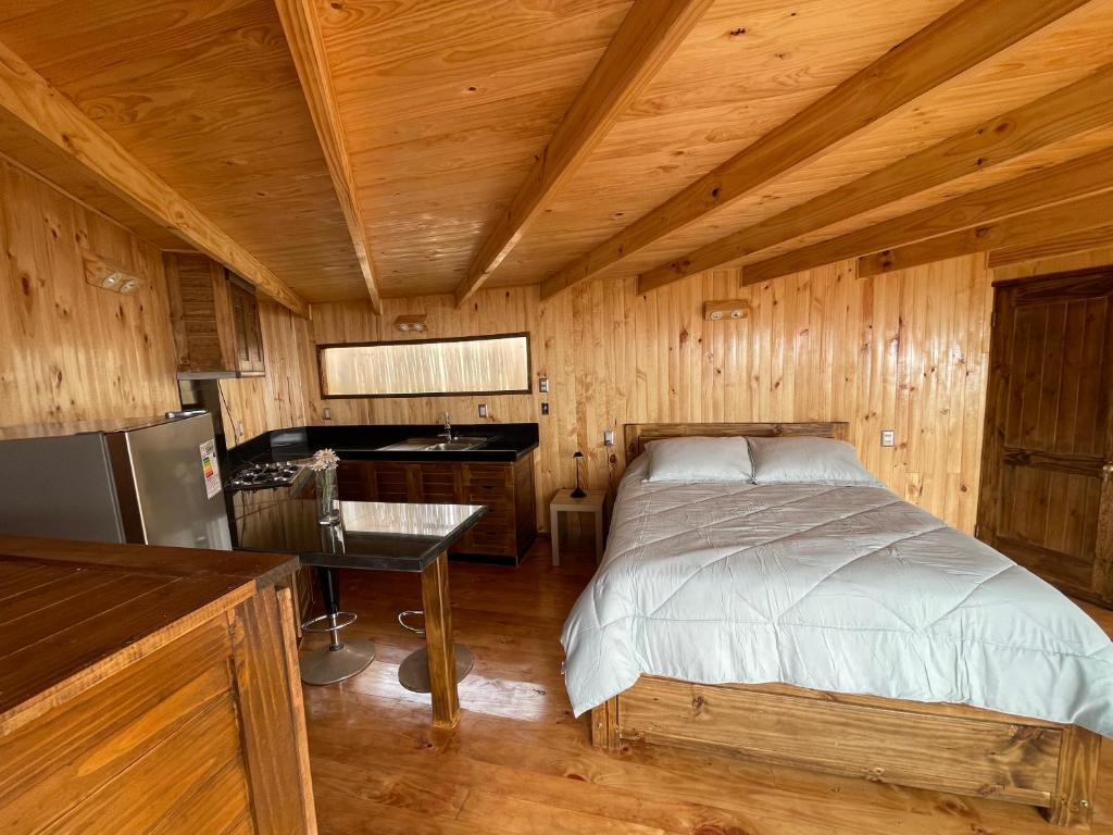 a bedroom with a bed in a wooden cabin at Casa al mare due - Matanzas y Pupuya in Navidad