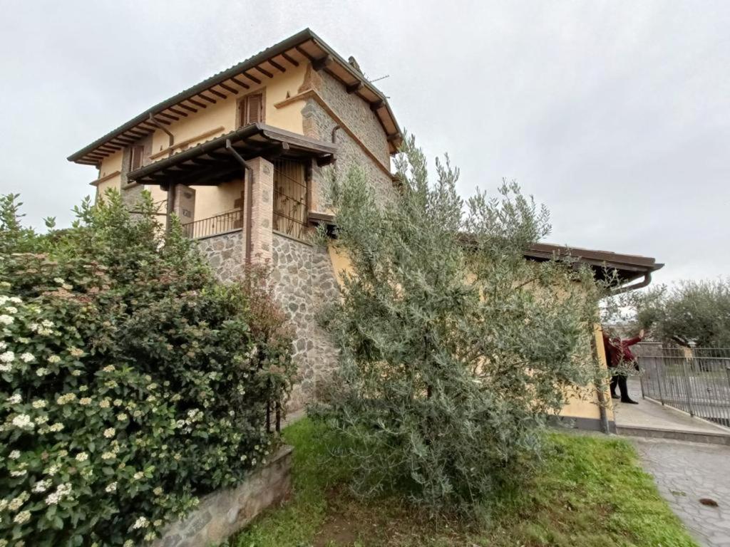 a woman walking past a house with a fence at La Casa del Nonno in Porano
