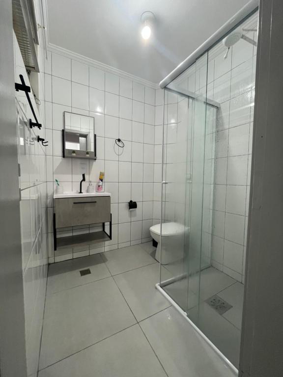 een badkamer met een douche, een wastafel en een toilet bij Apartamento 2 Guarujá enseada 2 dorm, 200m praia Ed Carpentier in Guarujá