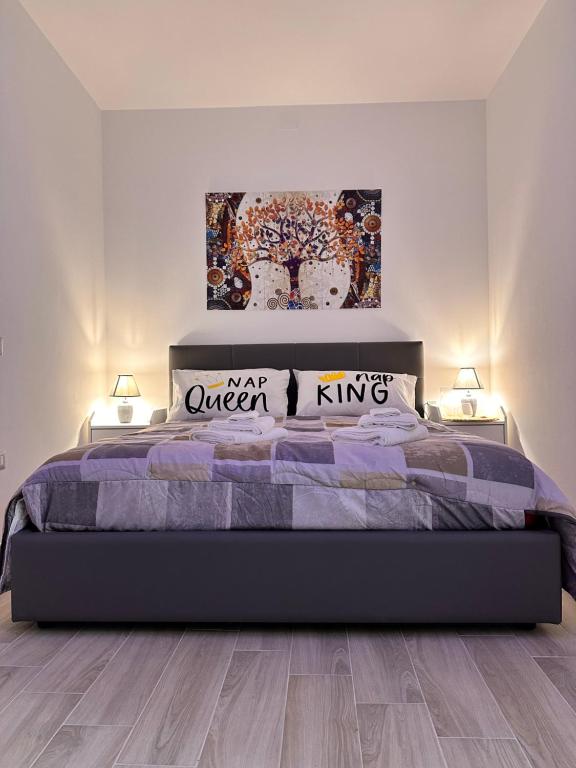 um quarto com uma cama grande e 2 candeeiros em Holidays Apartment em Cagliari