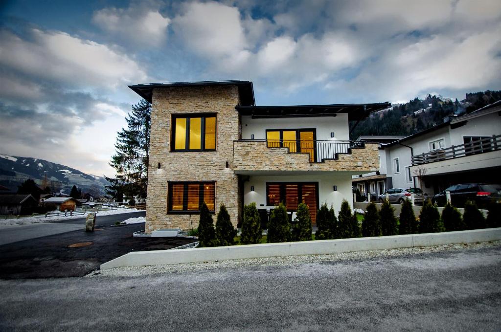 a large brick house with windows on a street at Kitz Juwel Top 2 in Hollersbach im Pinzgau