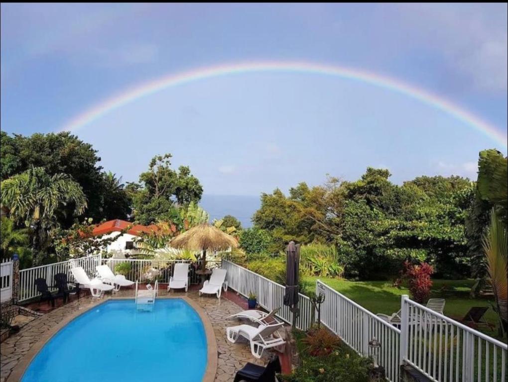 a rainbow over a swimming pool with at Bungalow Ti Papiyon in Bouillante