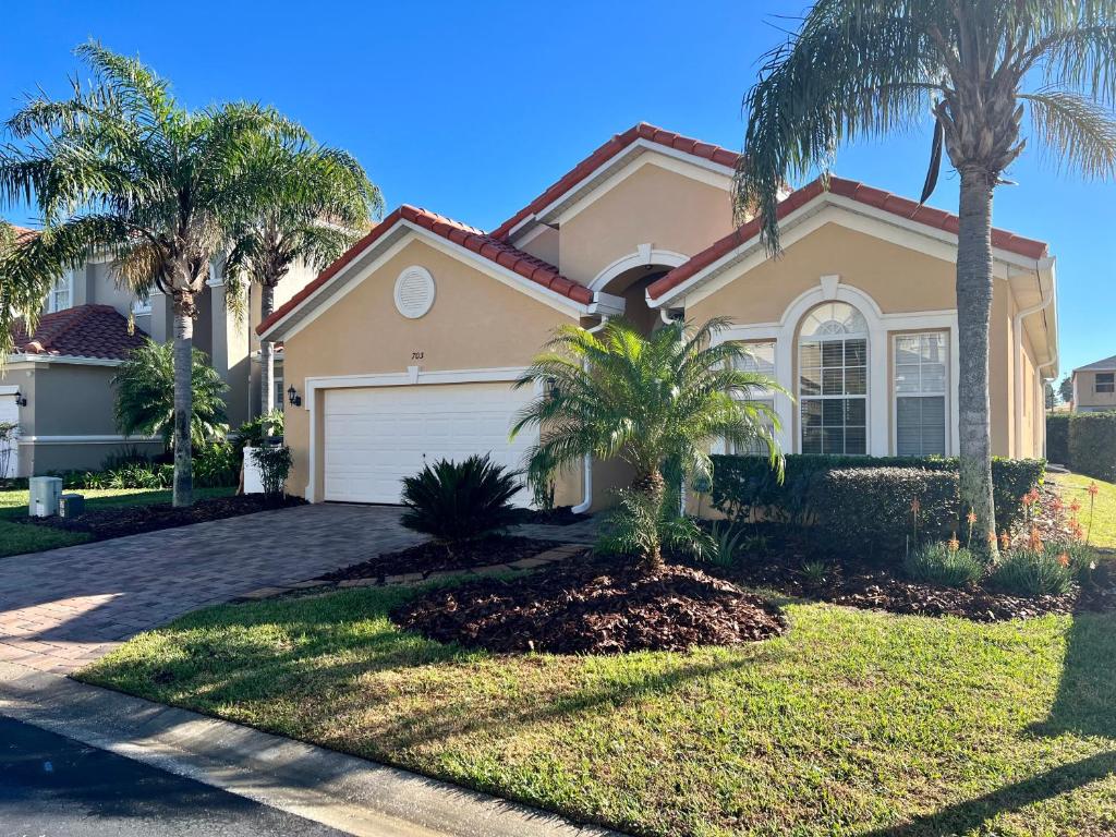 a house with palm trees in front of it at Tuscan Pines Villa in Davenport