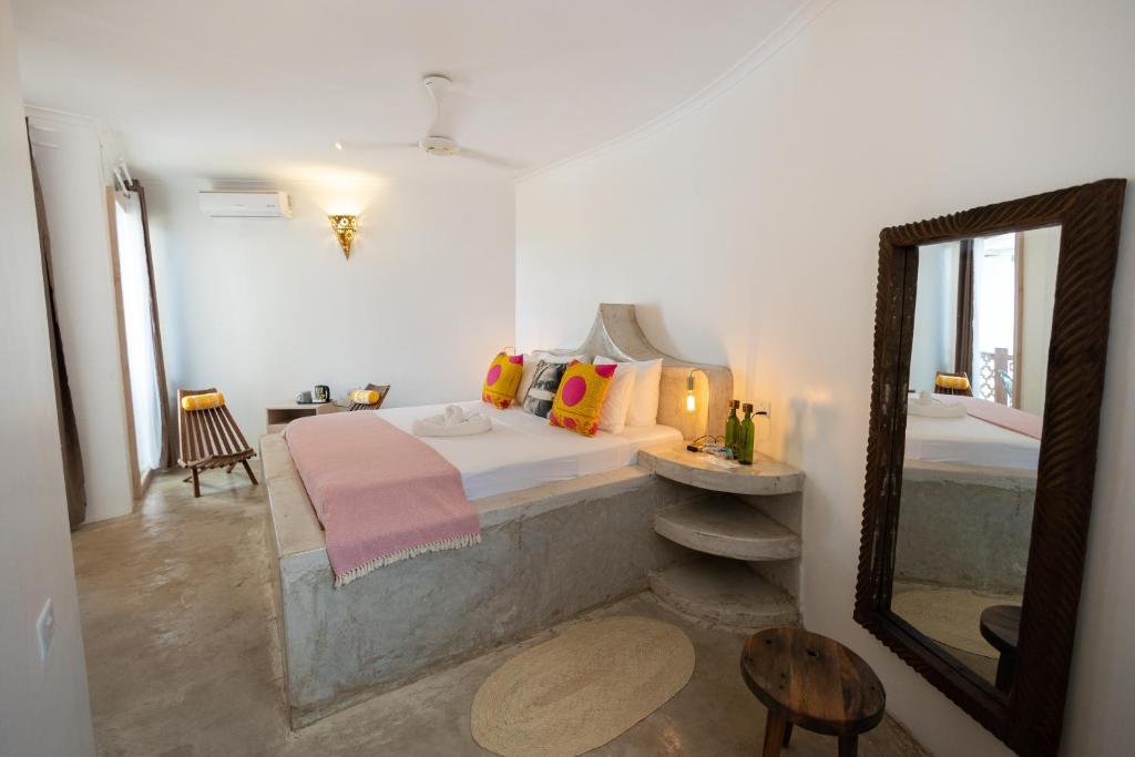 una camera con letto e specchio di Sharazad Wonders Boutique a Zanzibar City