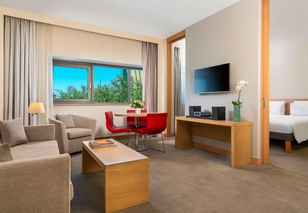 a hotel room with a bed and a living room at Novotel Gaziantep in Gaziantep