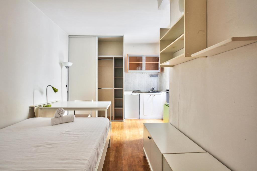 Cette petite chambre comprend un lit et une cuisine. dans l'établissement Charmant studio Paris 3 Marais, à Paris