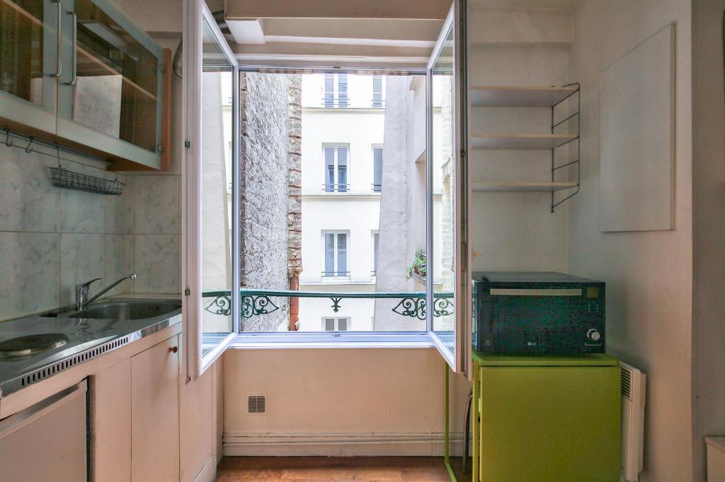 a kitchen with a window and a green refrigerator at Charmant studio Paris 3 Marais in Paris