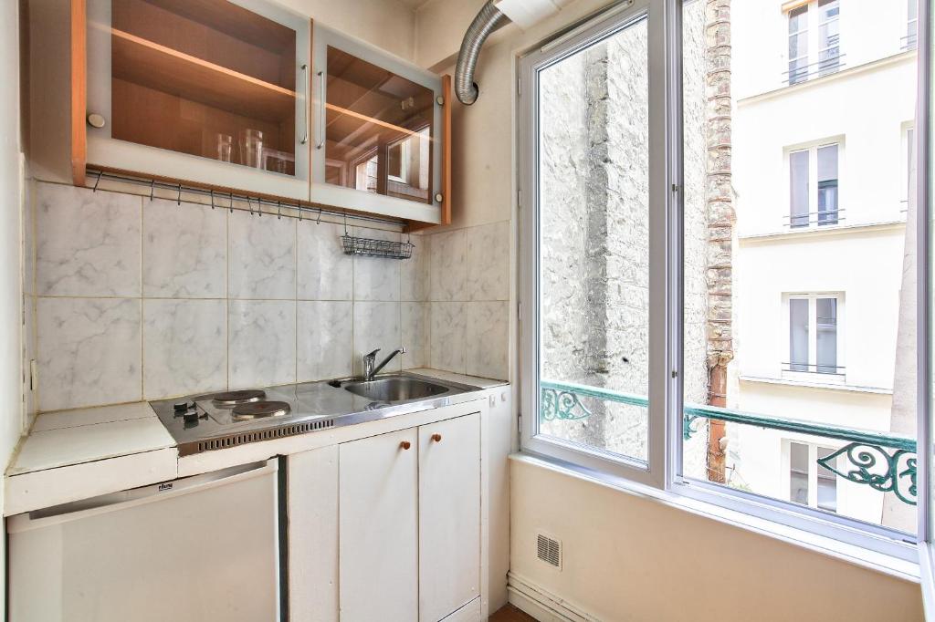 a small kitchen with a sink and a window at Charmant studio Paris 3 Marais in Paris