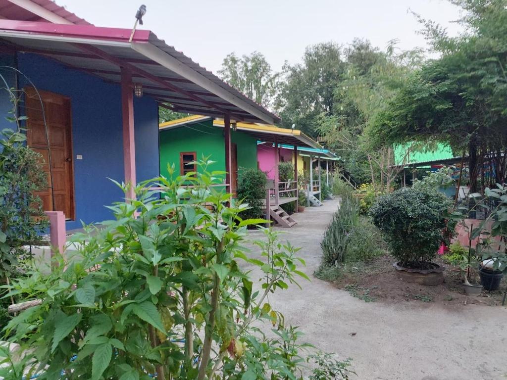 une rangée de maisons colorées dans un jardin dans l'établissement บ้านสวนนกโฮมสเตย์ OWLHOUSE, à Ban Pong Pat