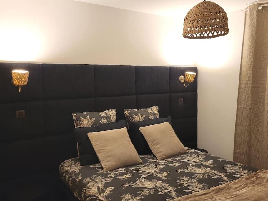um quarto com uma cama preta e 2 almofadas em Cosy Loft - Appartement de charme em Marsannay-la-Côte