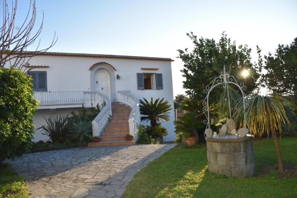 a white house with a staircase in front of a yard at Casa Ischia in Ischia