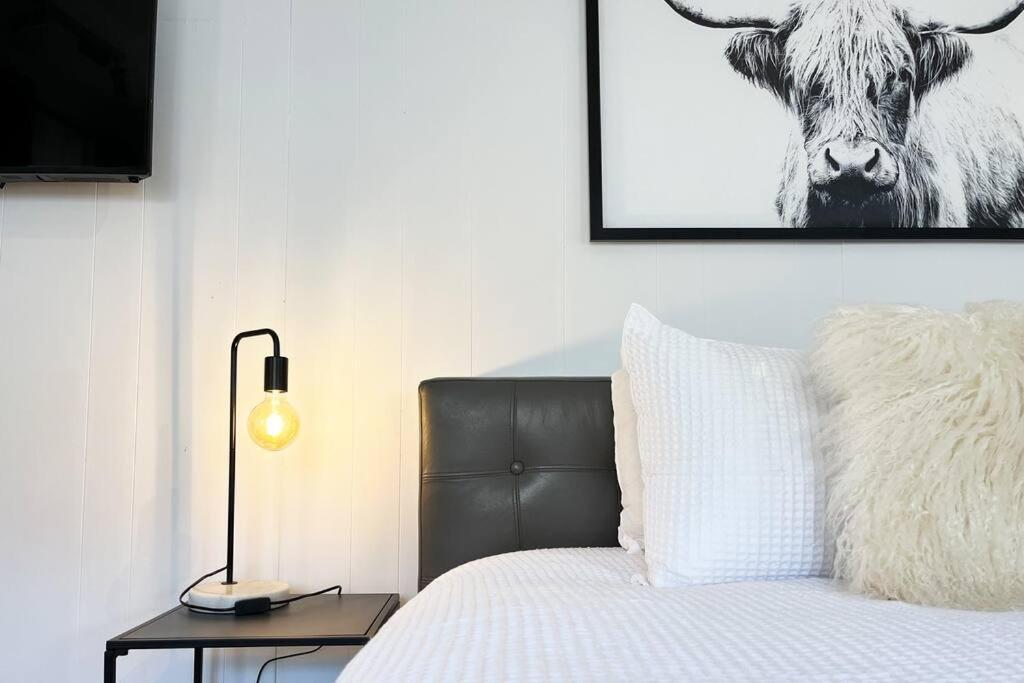 a bedroom with a bed and a picture of a cow at Studio C by Breckler Park in Perth
