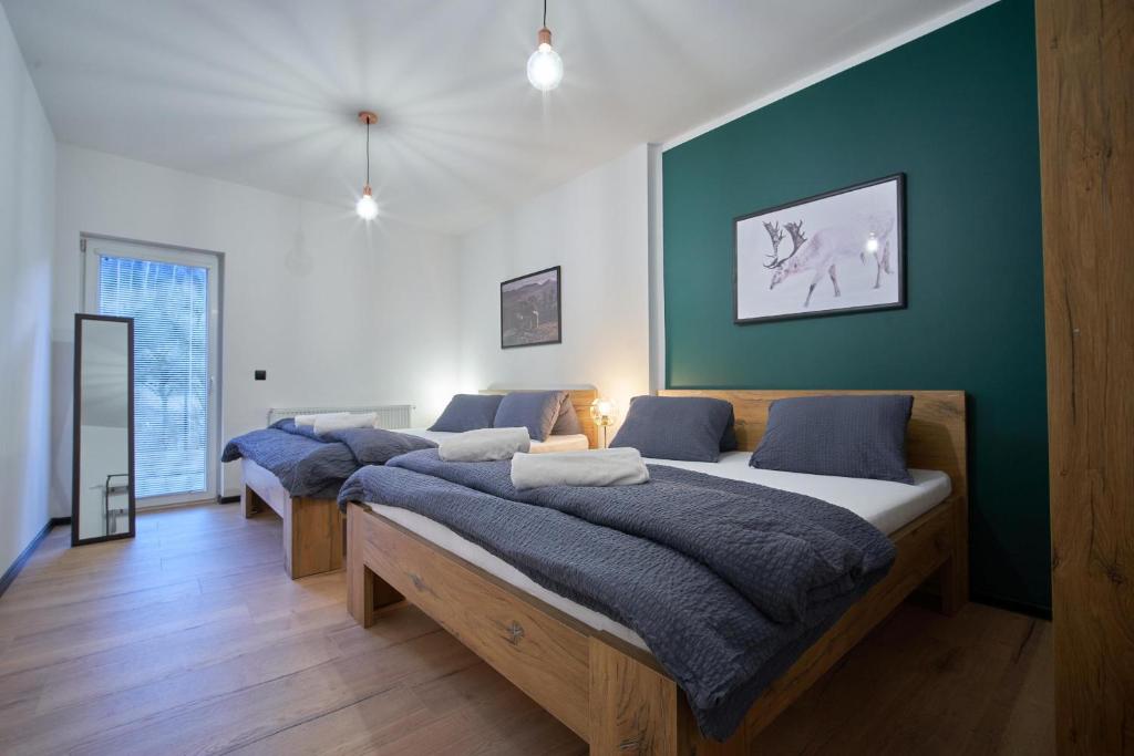 twee bedden in een kamer met een groene muur bij Apartmány U Rodinky in Lipova Lazne