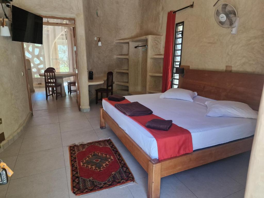1 Schlafzimmer mit einem großen Bett und einem Esszimmer in der Unterkunft LE KABOSS in Toliara