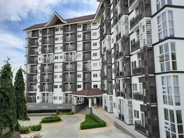 a large apartment building with a courtyard in front of it at Antara Residential Condominium in Talisay