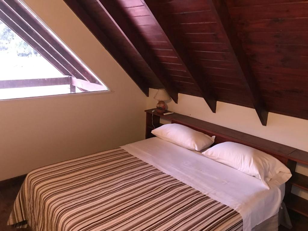 a bed with two pillows in a room with a window at Solares de la Bahía in Tigre