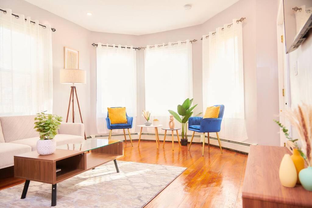 a living room with a white couch and blue chairs at Cozy apartment 1st 10min Walk Downtown and City View in Providence