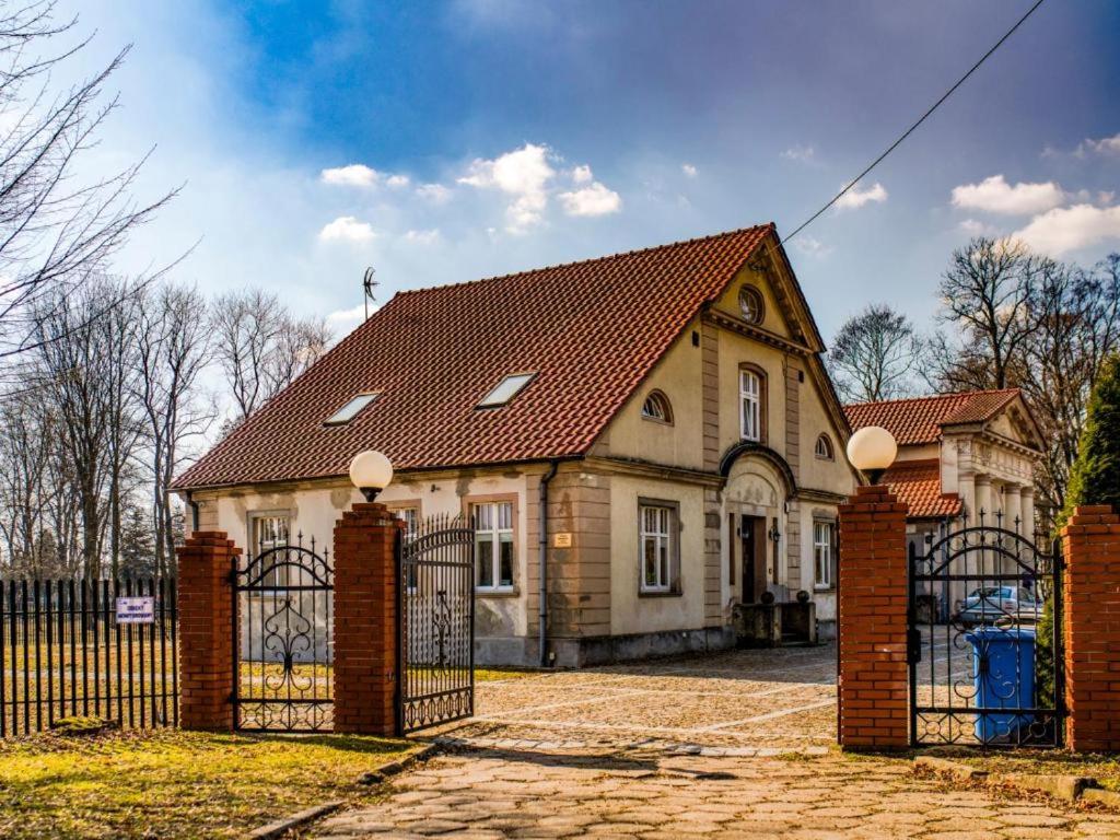 une maison avec une porte devant elle dans l'établissement Dworek Cieszków, à Cieszków