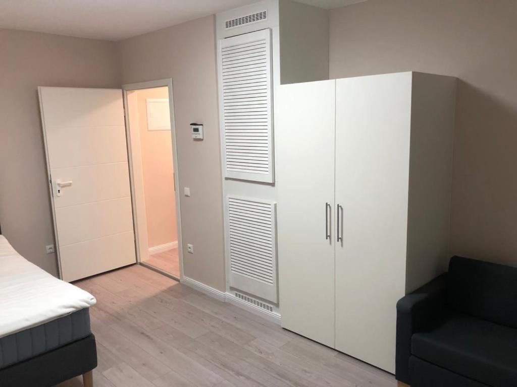 ein Schlafzimmer mit einem weißen Schrank und einem schwarzen Sofa in der Unterkunft Hochfeld Apartment in Augsburg in Augsburg