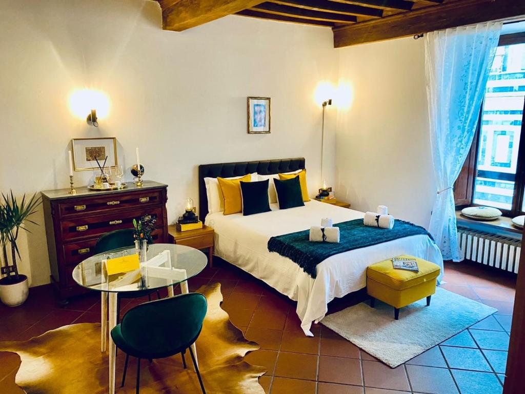 sypialnia z łóżkiem, stołem i krzesłami w obiekcie La Mandorla studio apartment in Piazza del Duomo we Florencji