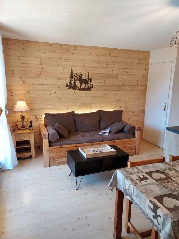 sala de estar con sofá y mesa en Villard je t'aime - Résidence Les Tennis - 2 Appartements 2 pièces 5 p et 6 p, en Villard-de-Lans