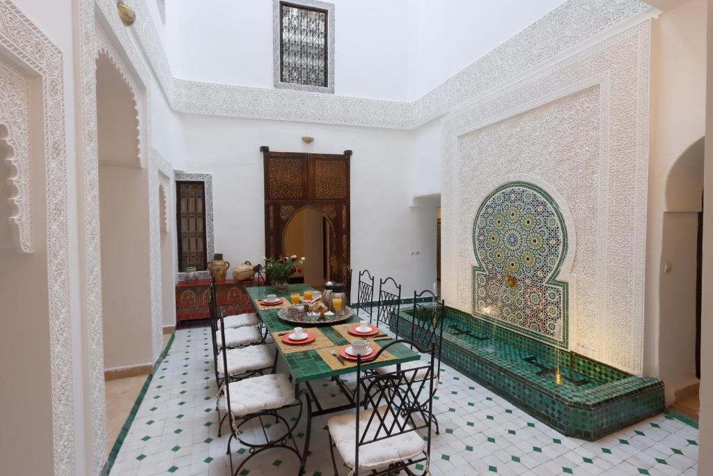 ein Esszimmer mit einem Tisch und Stühlen in der Unterkunft Riad Jenan L'mouassine in Marrakesch