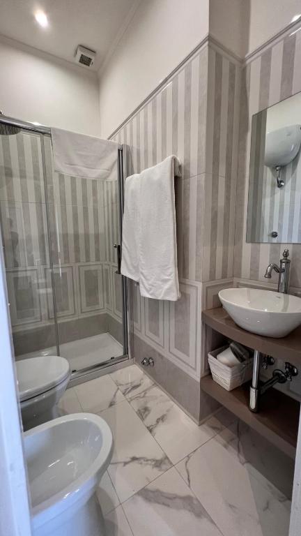 łazienka z umywalką, toaletą i prysznicem w obiekcie Calabritto Suite w mieście Neapol