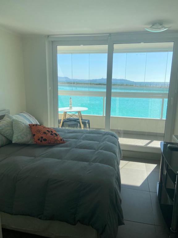 1 dormitorio con cama y vistas al océano en apartamento, en La Serena