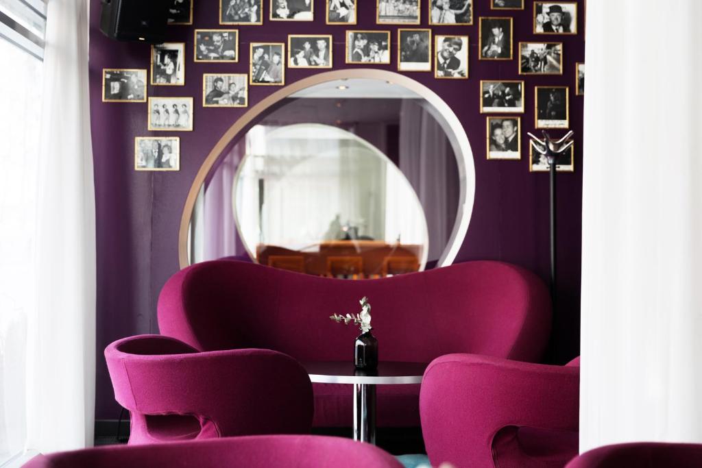 a room with purple chairs and a mirror at ProfilHotels Aveny in Umeå