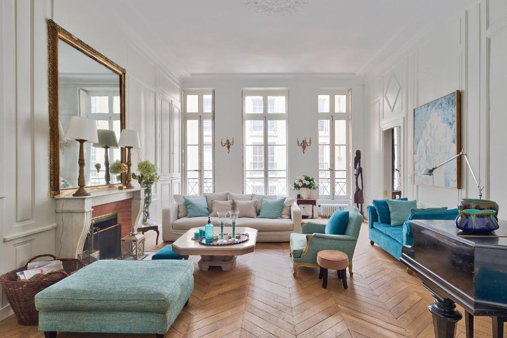 a living room with blue furniture and a piano at Appartement de standing sur l'île Saint-Louis by Weekome in Paris