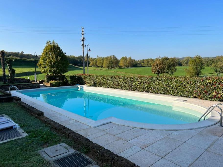 a swimming pool in a yard with a hedge at Limone Apartment - Featuring a Private Garden and Access to a Pool in Barcuzzi