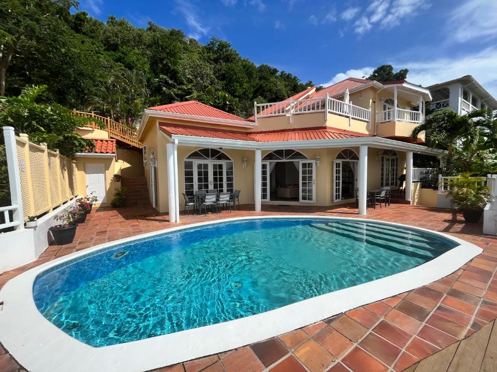 a swimming pool in front of a house at Stunning 4-Bed Villa in Gros Islet St Lucia in Bois dʼOrange