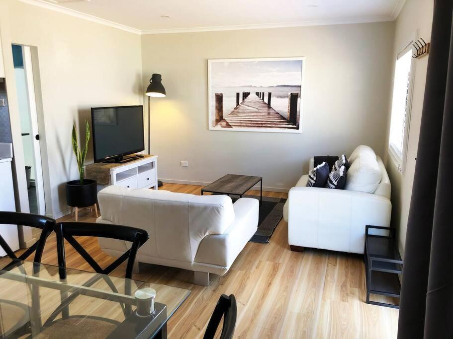 a living room with a white couch and a tv at The Central Shed - 10B in Geraldton