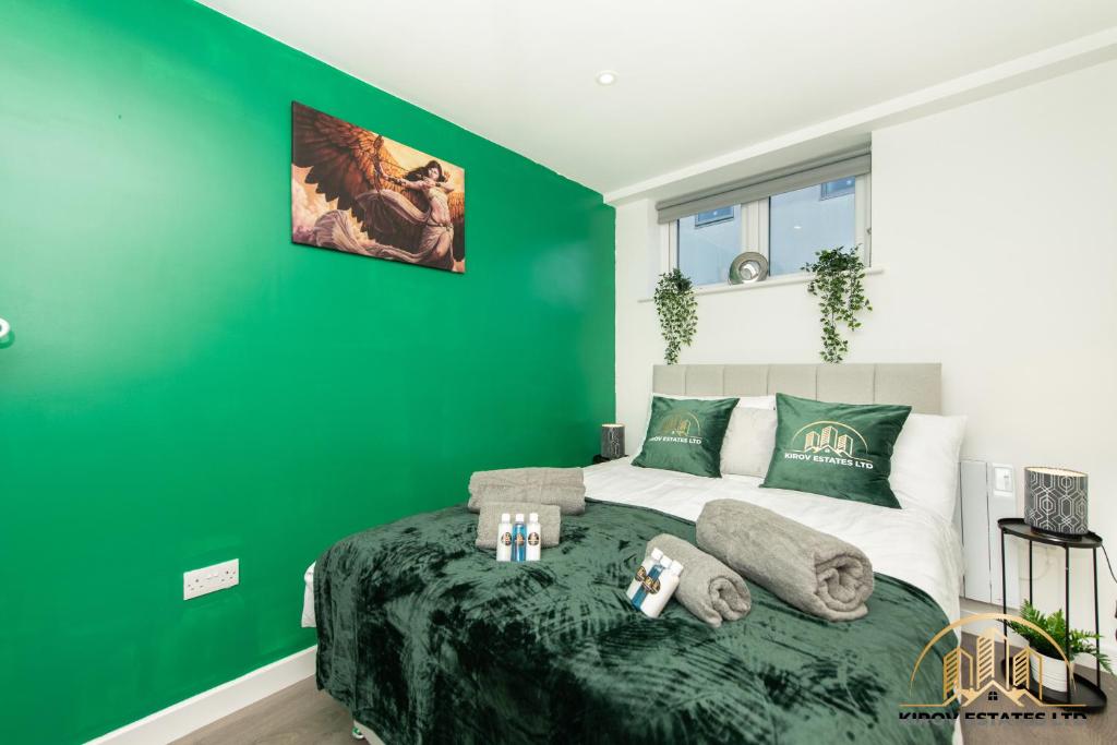 a green bedroom with a bed with a green wall at Artemis Apartment - The Hunting Watch of Town in Southampton