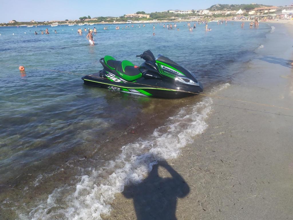 a shadow of a man standing next to a jet ski on the beach at Casa vacanze in Berchidda