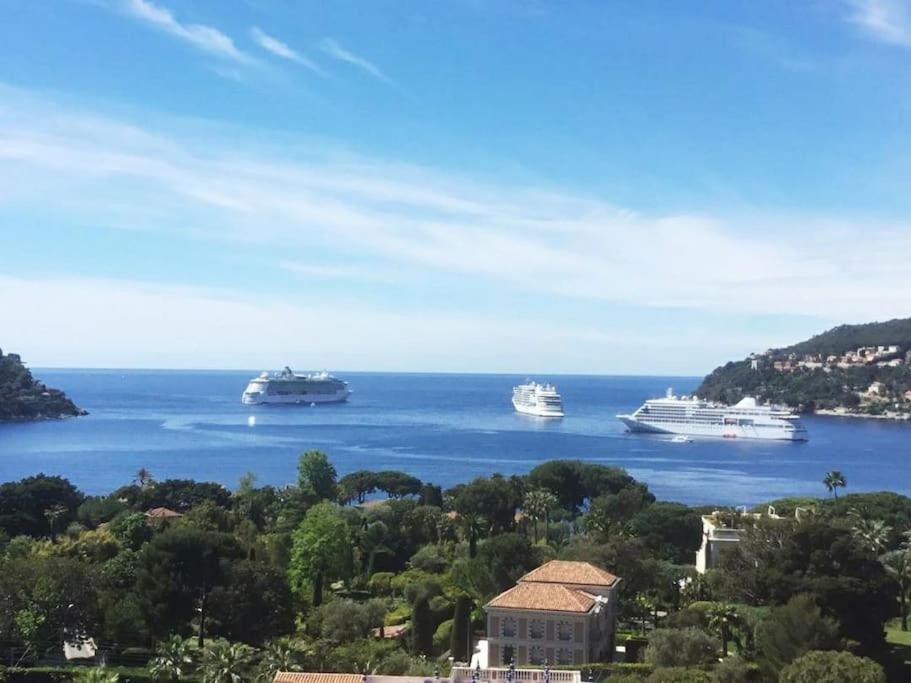 three cruise ships in the water in a bay at Bel appartement climatisé vue mer parking gratuit. in Villefranche-sur-Mer
