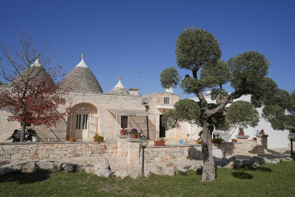 a stone house with a tree in front of it at Antiche Dimore TerraRossa in Alberobello